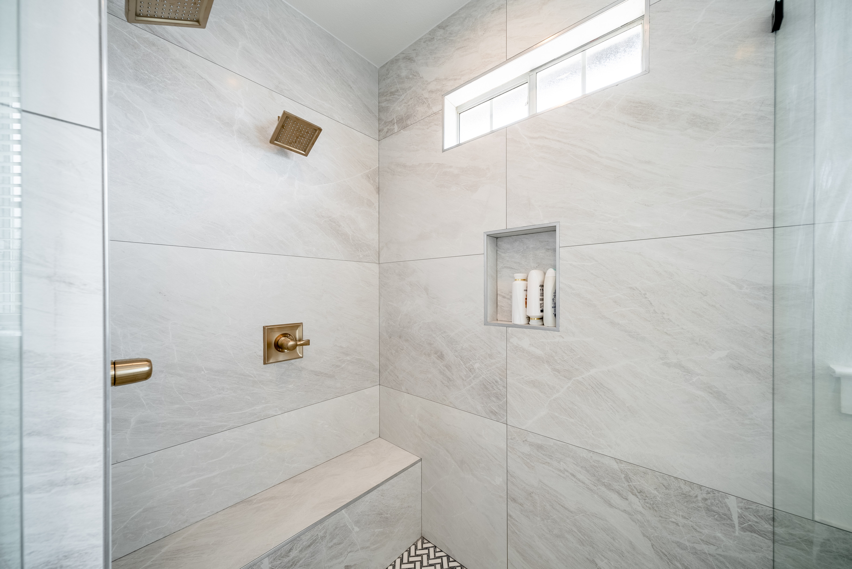 Spa-inspired walk-in shower with a built-in bench and marble-tiled walls.