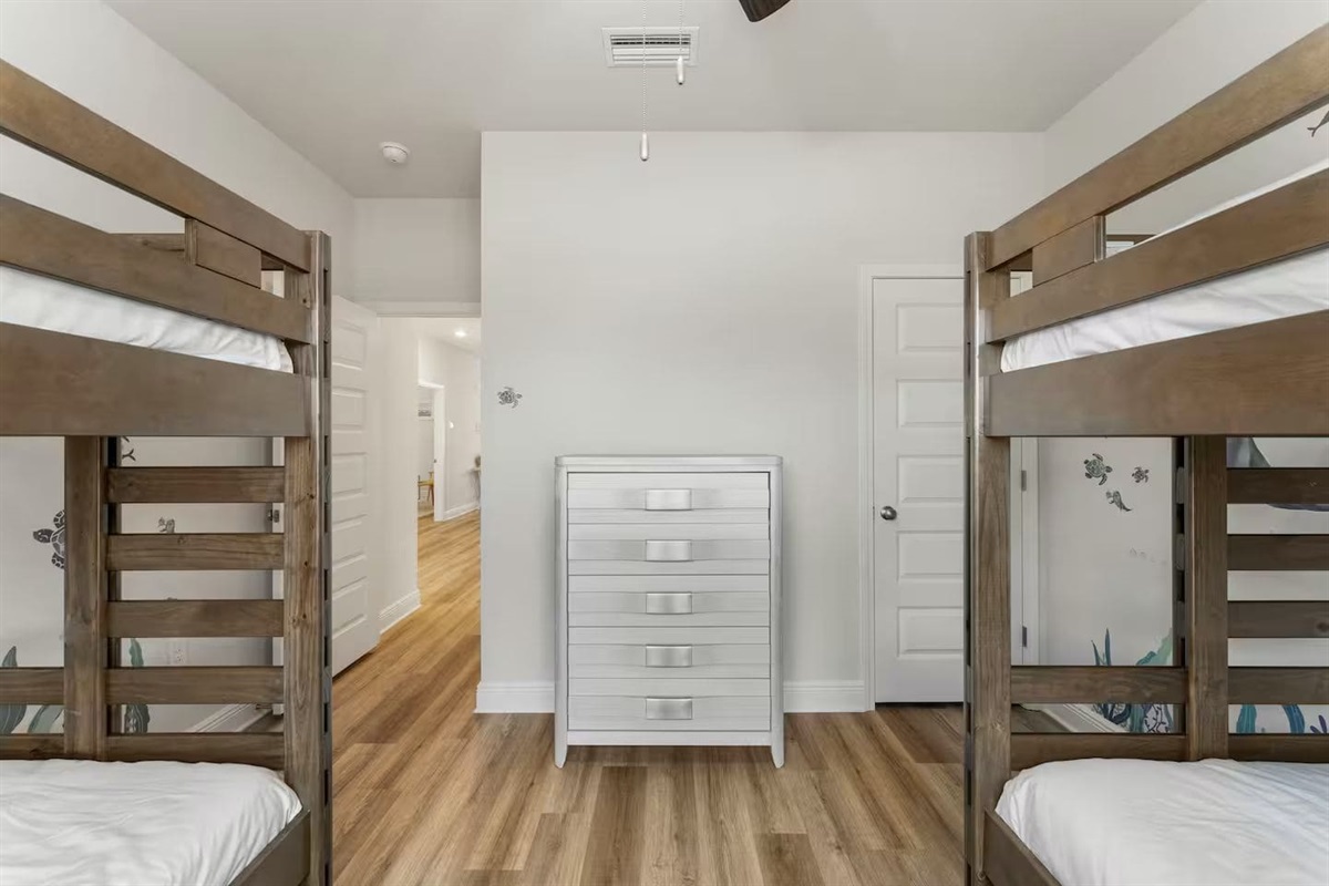 A cozy and practical bunk-bed room with windows and plenty of space.