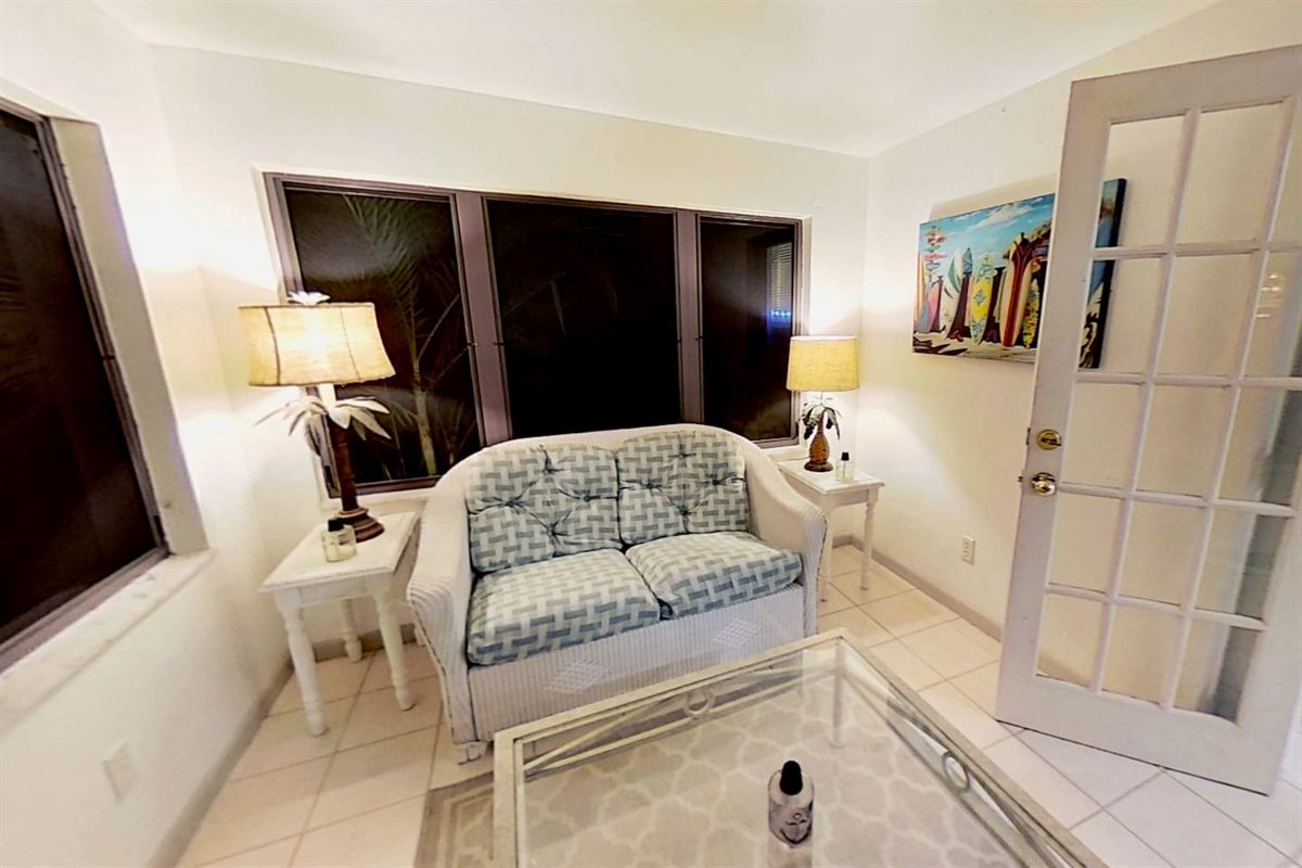 Screened Lanai with comfortable seating and french doors that open to let the outside in.