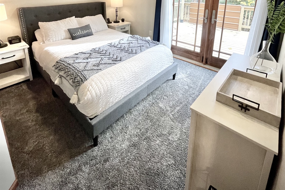 Main Cottage Bedroom view to back deck, with provided breakfast tray, two wireless phone charging stations. French doors plenty of light 