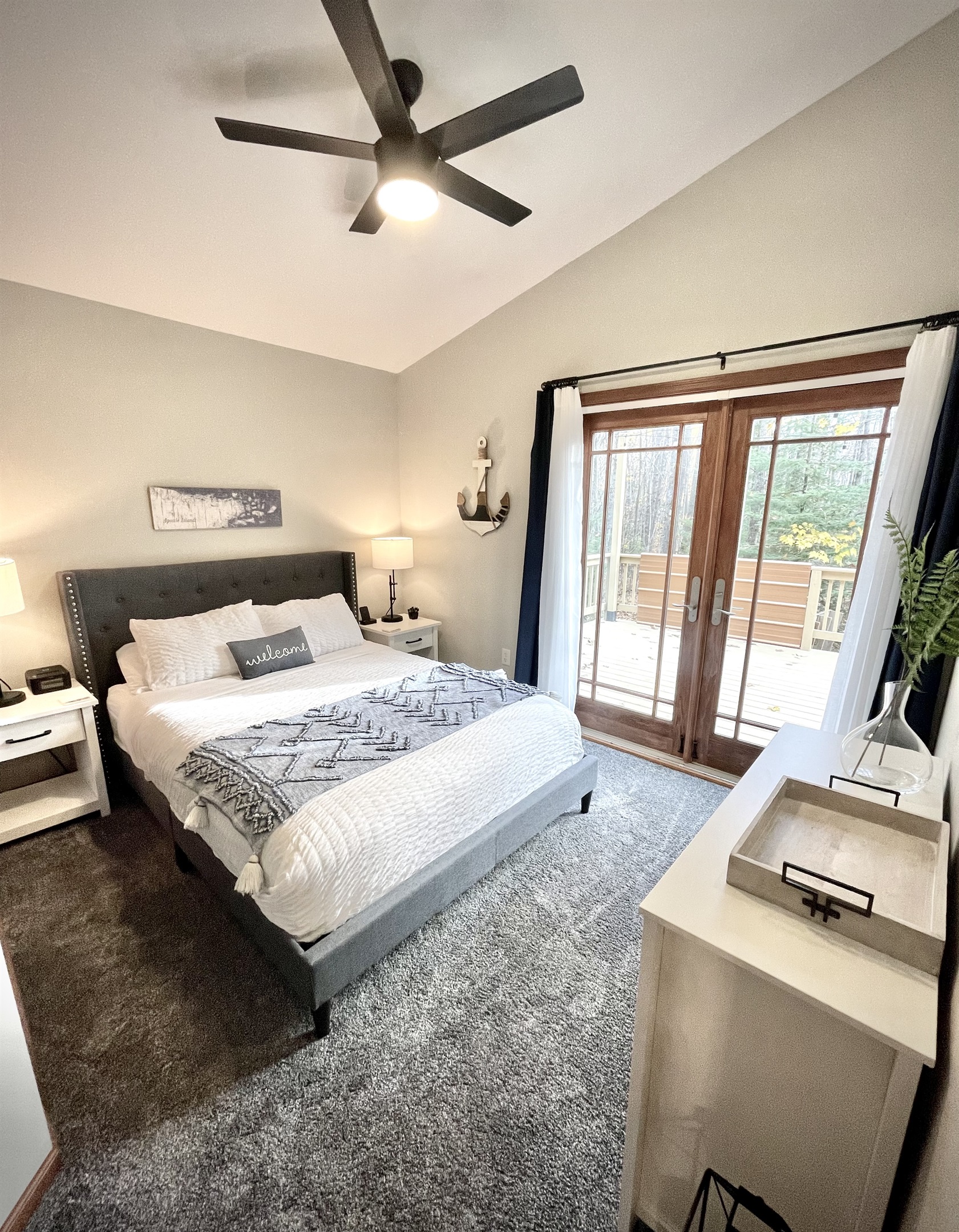 Main Cottage Bedroom view to back deck, with provided breakfast tray, two wireless phone charging stations. French doors plenty of light 