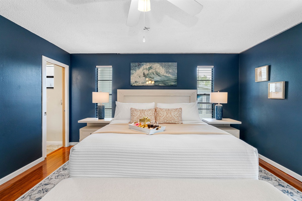 Featuring a luxurious king-size bed framed by a plush upholstered headboard and footboard with built-in storage, this room blends functionality and elegance effortlessly.