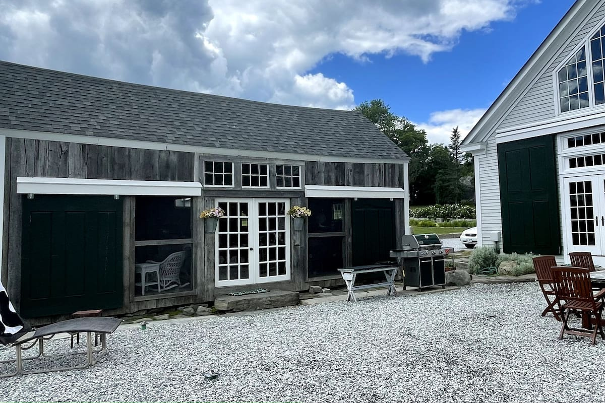 Screened in porch and dining area overlooking the terrace. The barn doors can be closed to allow for warmth and privacy.
