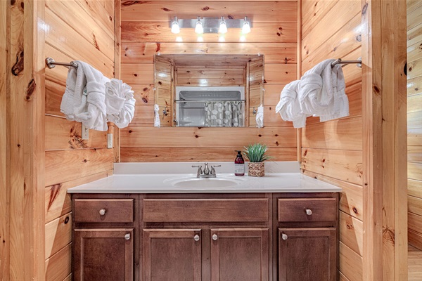 Rustic charm complete with soft lighting and cabin character in the primary en-suite bath.