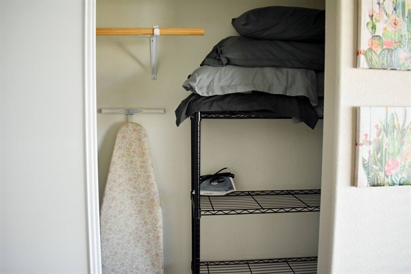 Extra blankets & pillows, iron and ironing board in closet