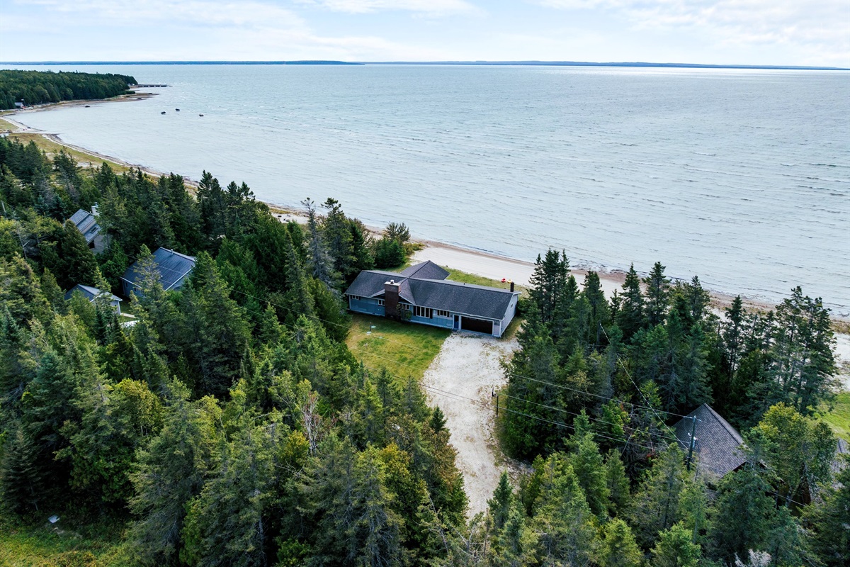 Towering pines and a soft, sandy beach welcome you