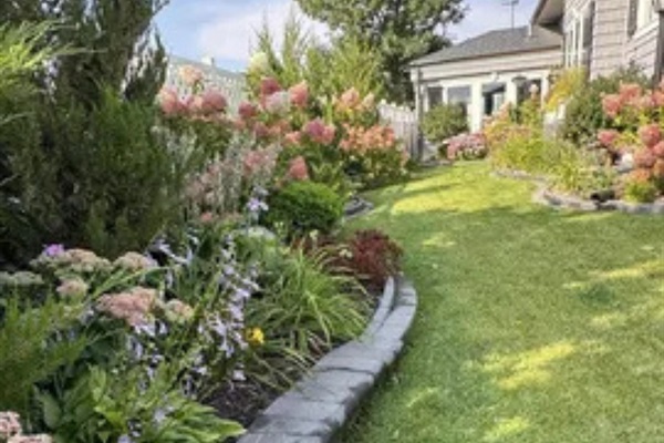 Beautiful flowers, fresh greenery, and a manicured yard make the outdoor space easy to enjoy.