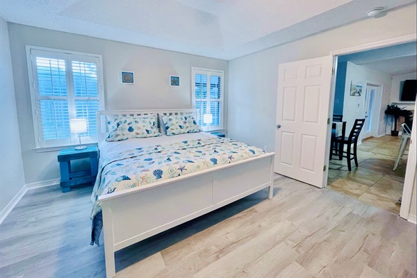 Primary King bedroom featuring Dream Cloud mattress, plush linens, and view out to the lanai