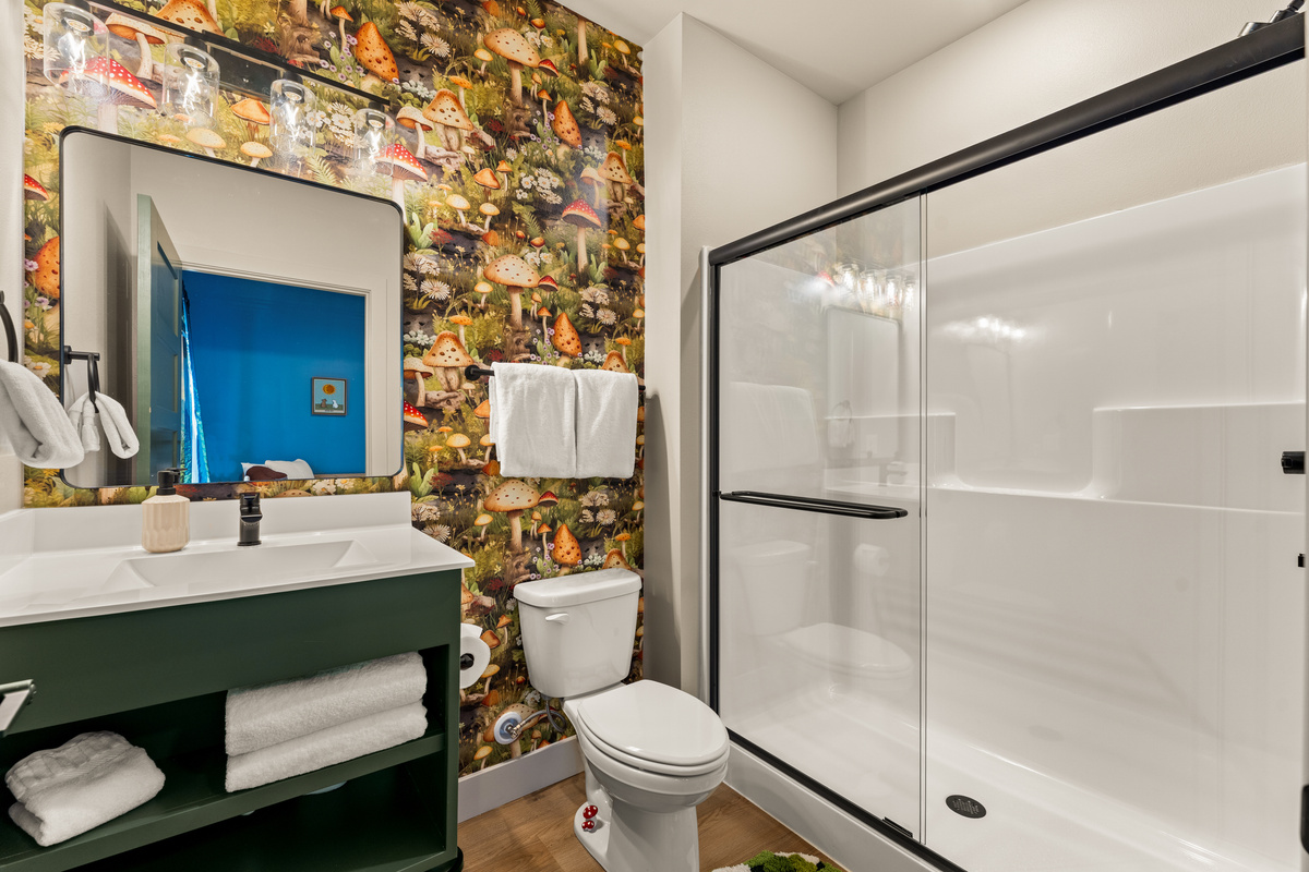 Bathroom: Beautiful full bathroom featuring a spacious walk-in shower, bold accent wall, and modern vanity.
