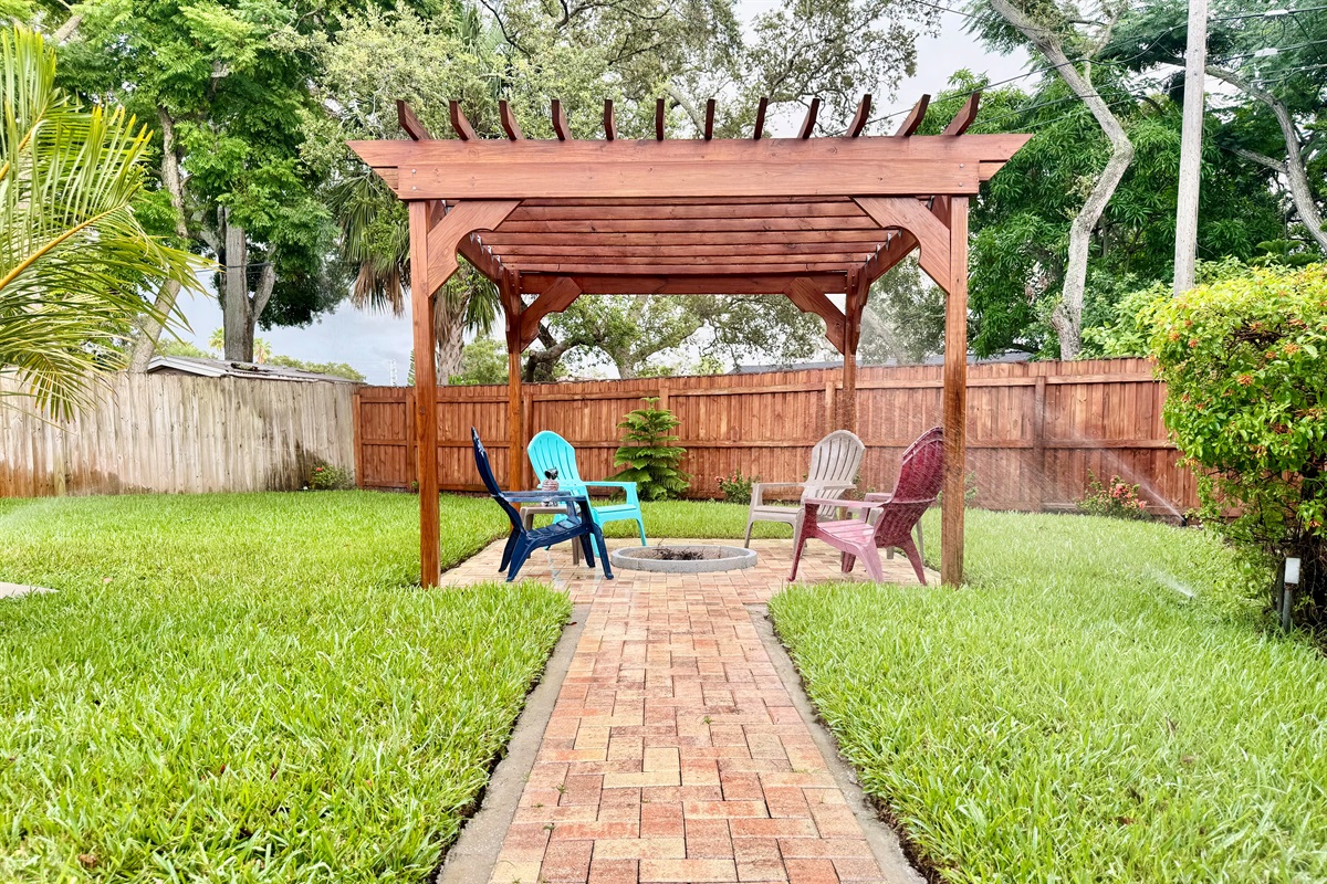 The perfect blend of natural wood, paver flooring, and cozy seating—this pergola space was made for memories.