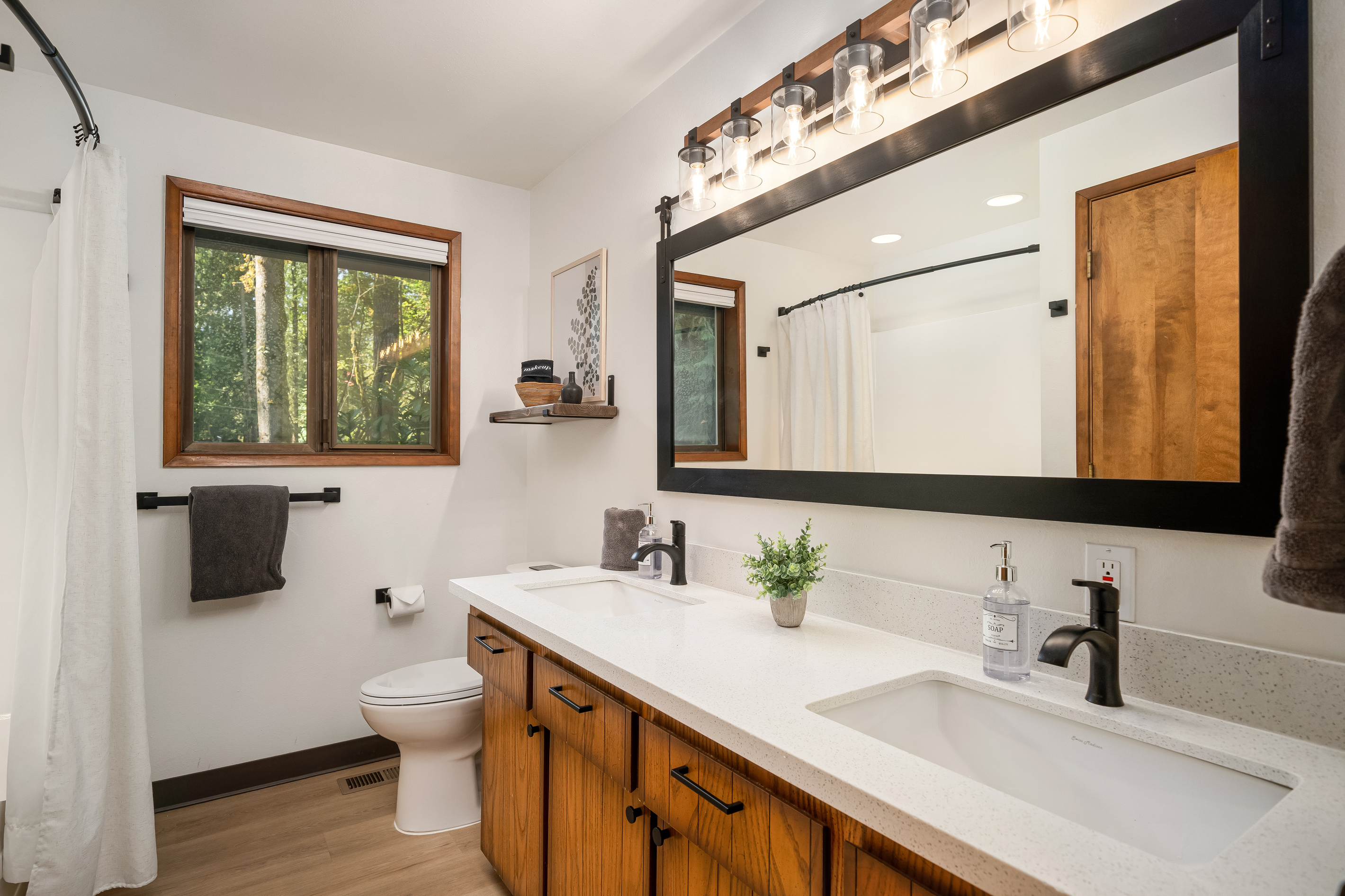 A double vanity with warm wood accents — room for the whole group to get ready.