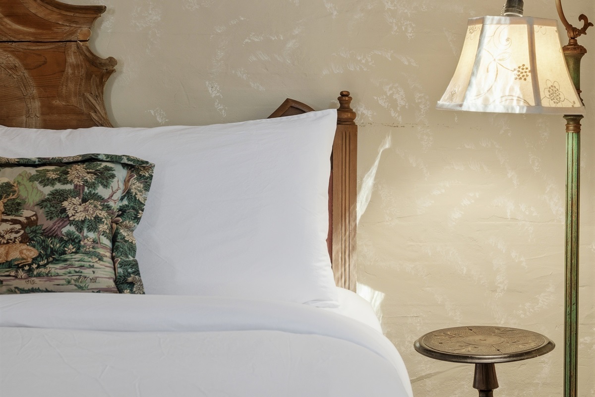 Plush bed dressed in crisp linens for a restful night’s sleep
