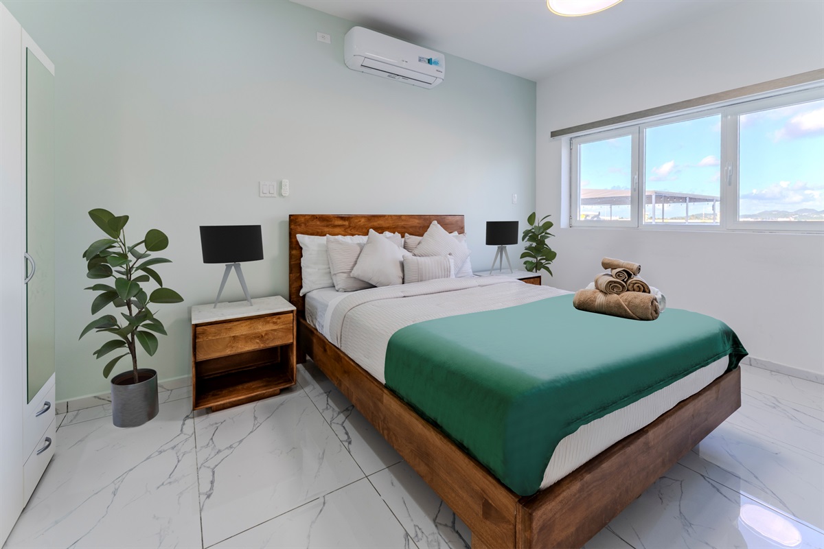 Cozy Second Bedroom with Queen Bed, Warm Wood Furnishings & Natural Light