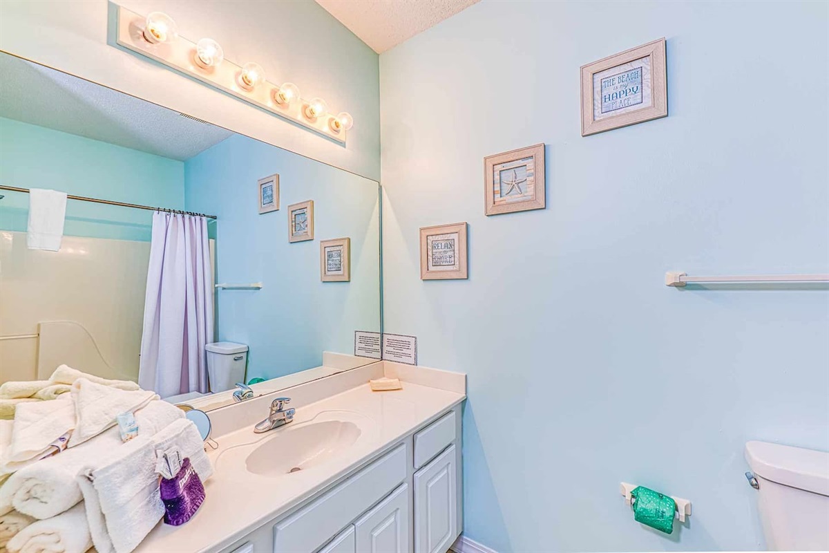 Bathroom Bliss: Bright coastal decor with soft hues and modern fixtures awaits your refresh!