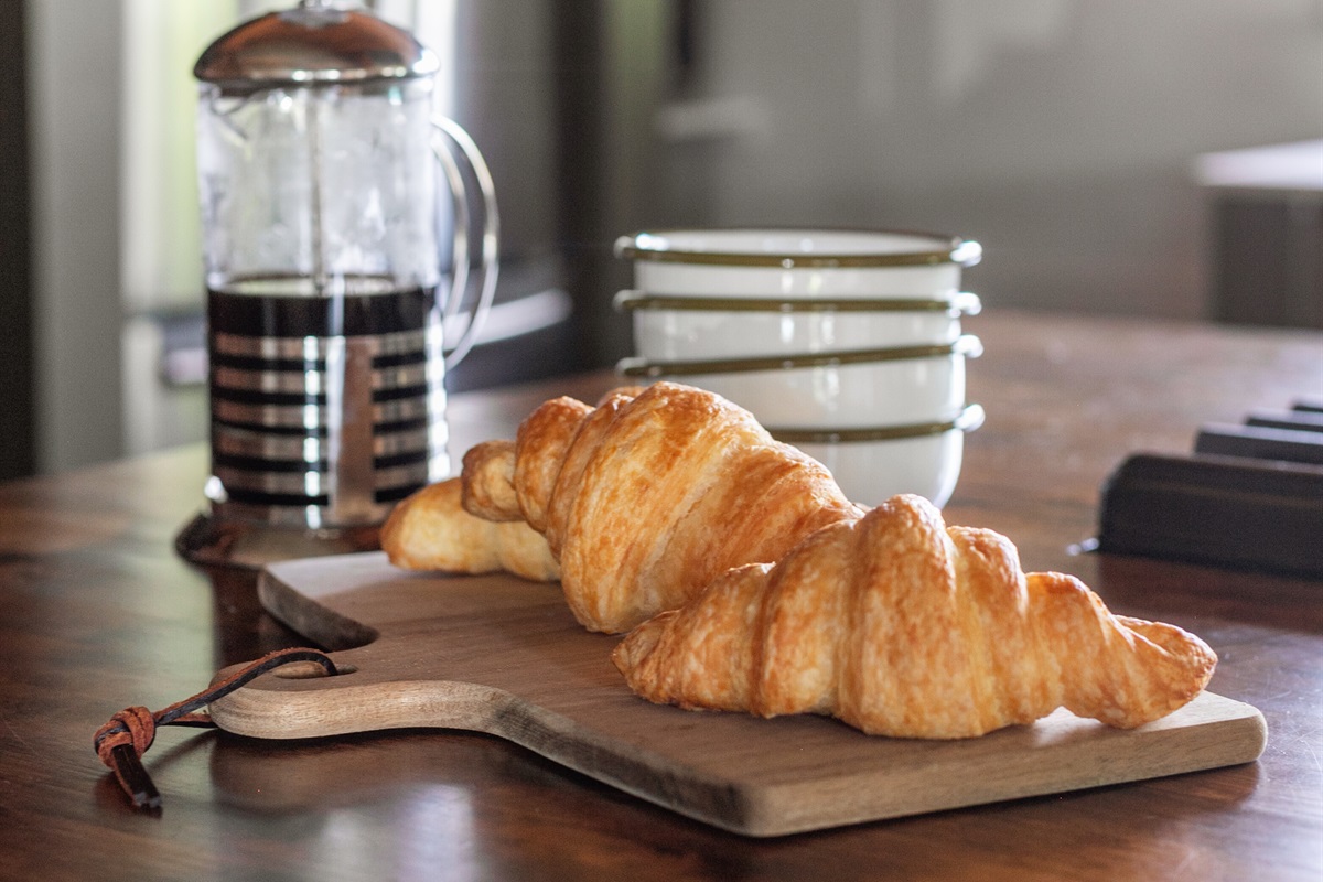 Morning begins at the island, where a French press and fresh croissant wait alongside simple, modern dishware. It’s a space that feels both stylish and welcoming — a place to pause, sip coffee, and ease into the day before the bustle begins.