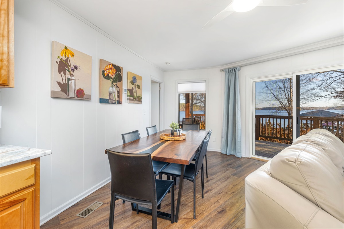 Dining Room: Gather around the stunning wood table with views of the serene lake and vibrant art!