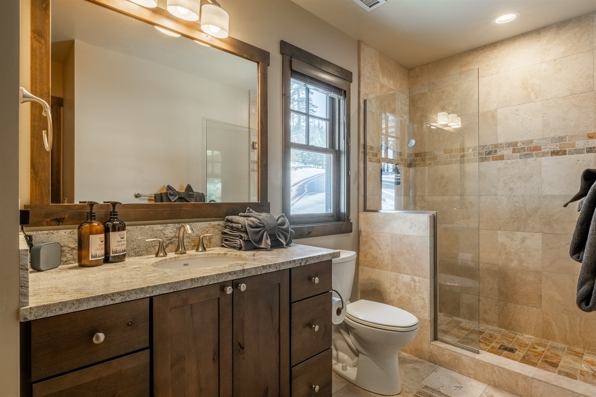 A second ensuite bath features a sleek walk-in shower, offering privacy and comfort for additional guests.