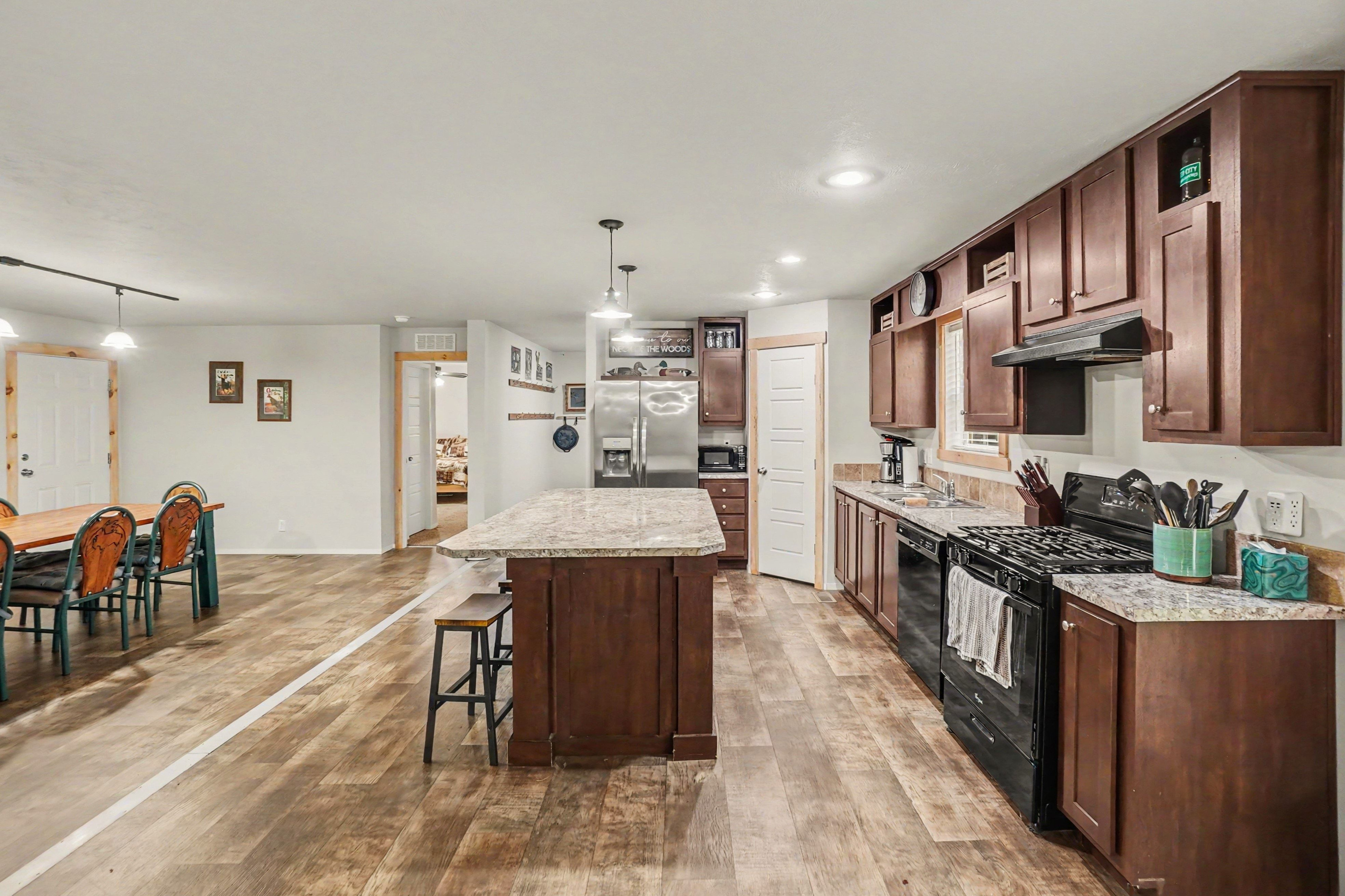 Large kitchen with large island, dishwasher, stove, refrigerator, microwave and coffee maker.