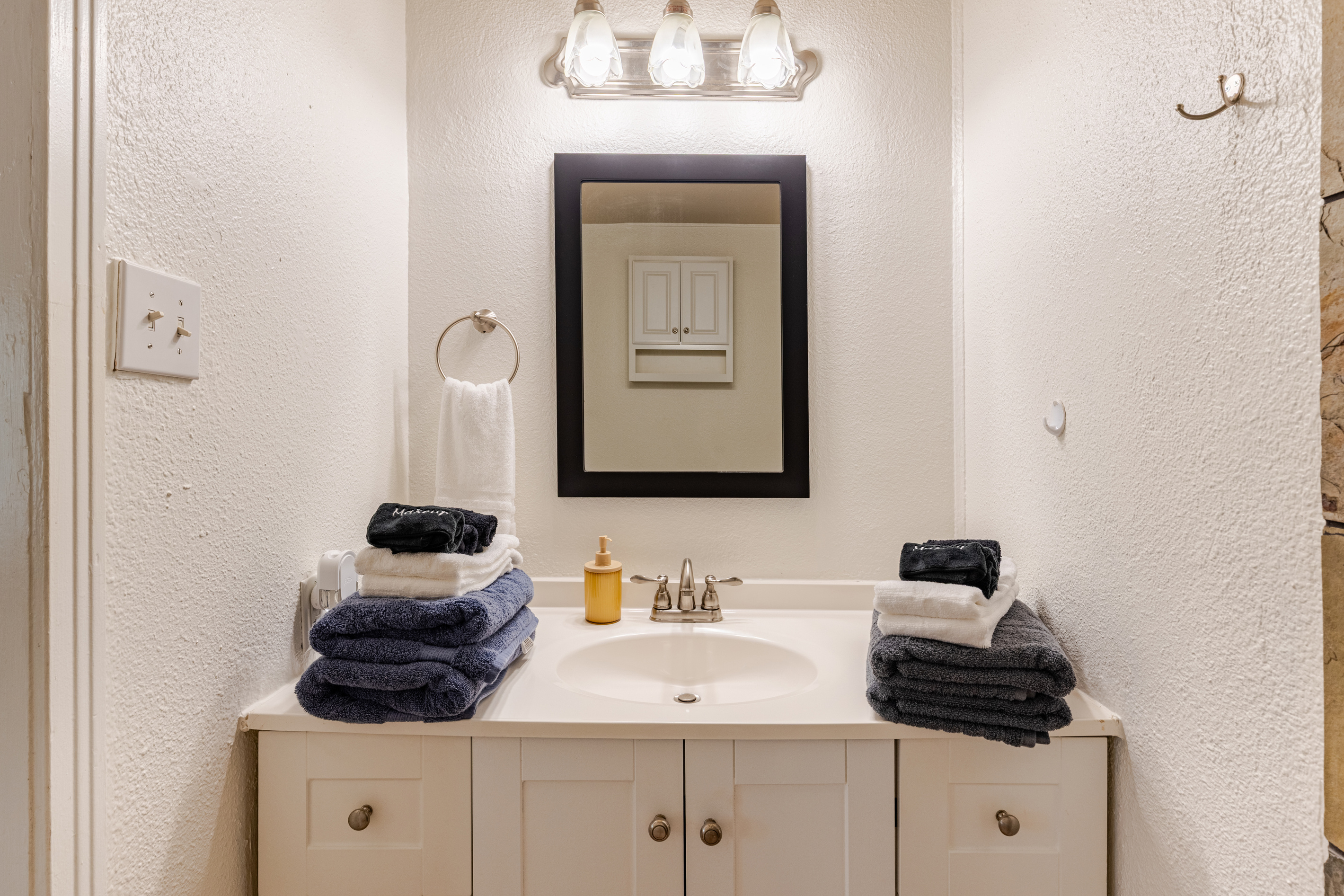 Bright and inviting with fresh towels and a sleek mirror for your relaxation needs!