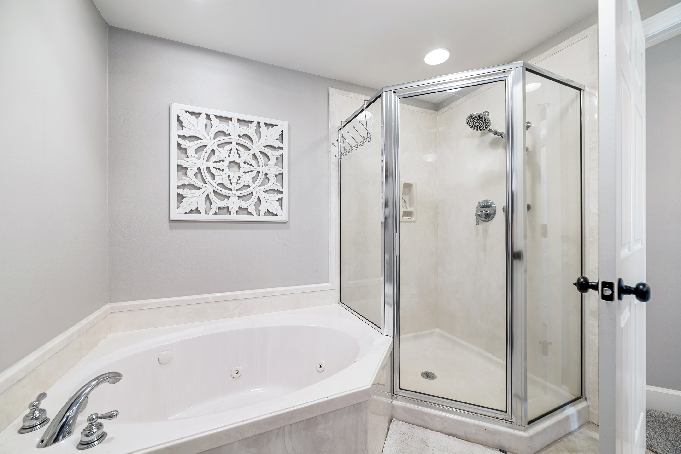 Indulge in tranquility in this well-appointed bathroom featuring a relaxing soaking tub and a separate glass-enclosed walk-in shower. A perfect space to unwind and rejuvenate.