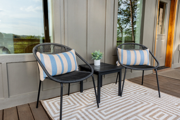 Relax on the lower covered deck with this cozy bistro set. Sink into the woven chairs and sip your morning cappuccino while enjoying the peaceful view of the rolling pasture and distant mountains. Perfect for unwinding in the fresh mountain air.