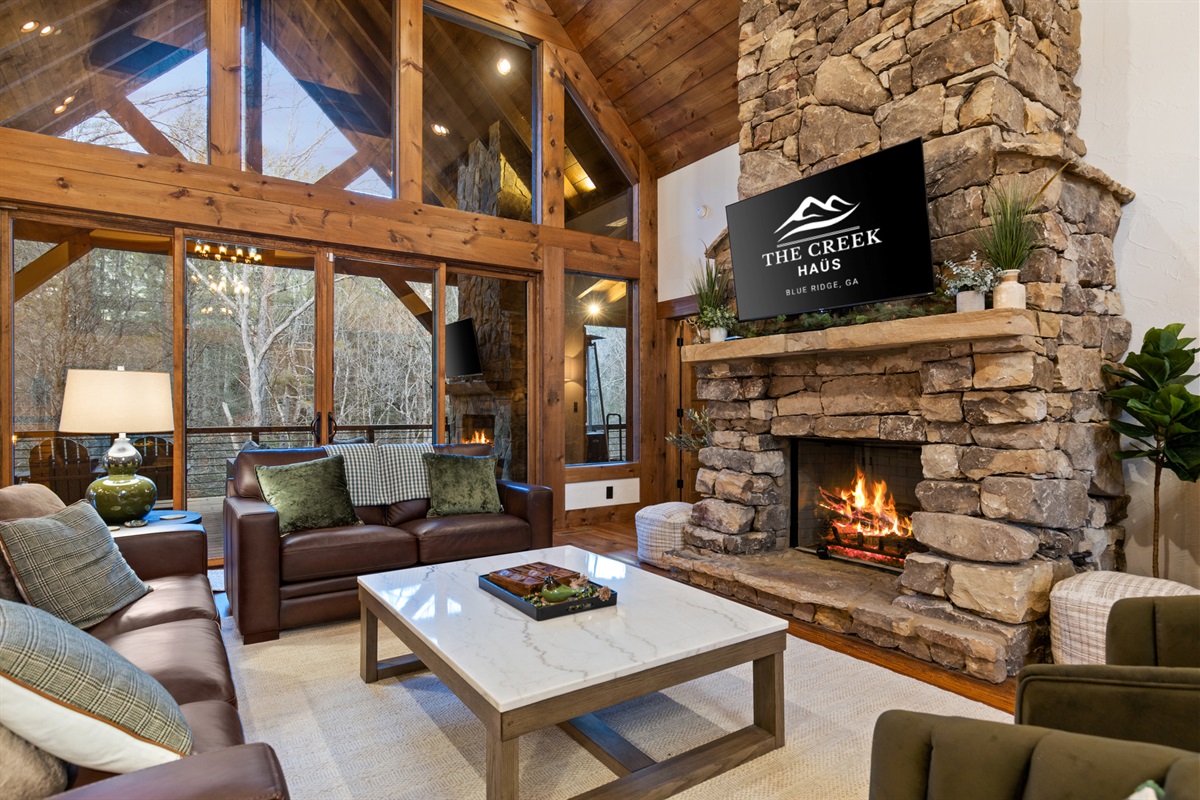 Enjoy breathtaking views of the surrounding woods from the comfort of the main living room&rsquo;s plush seating.