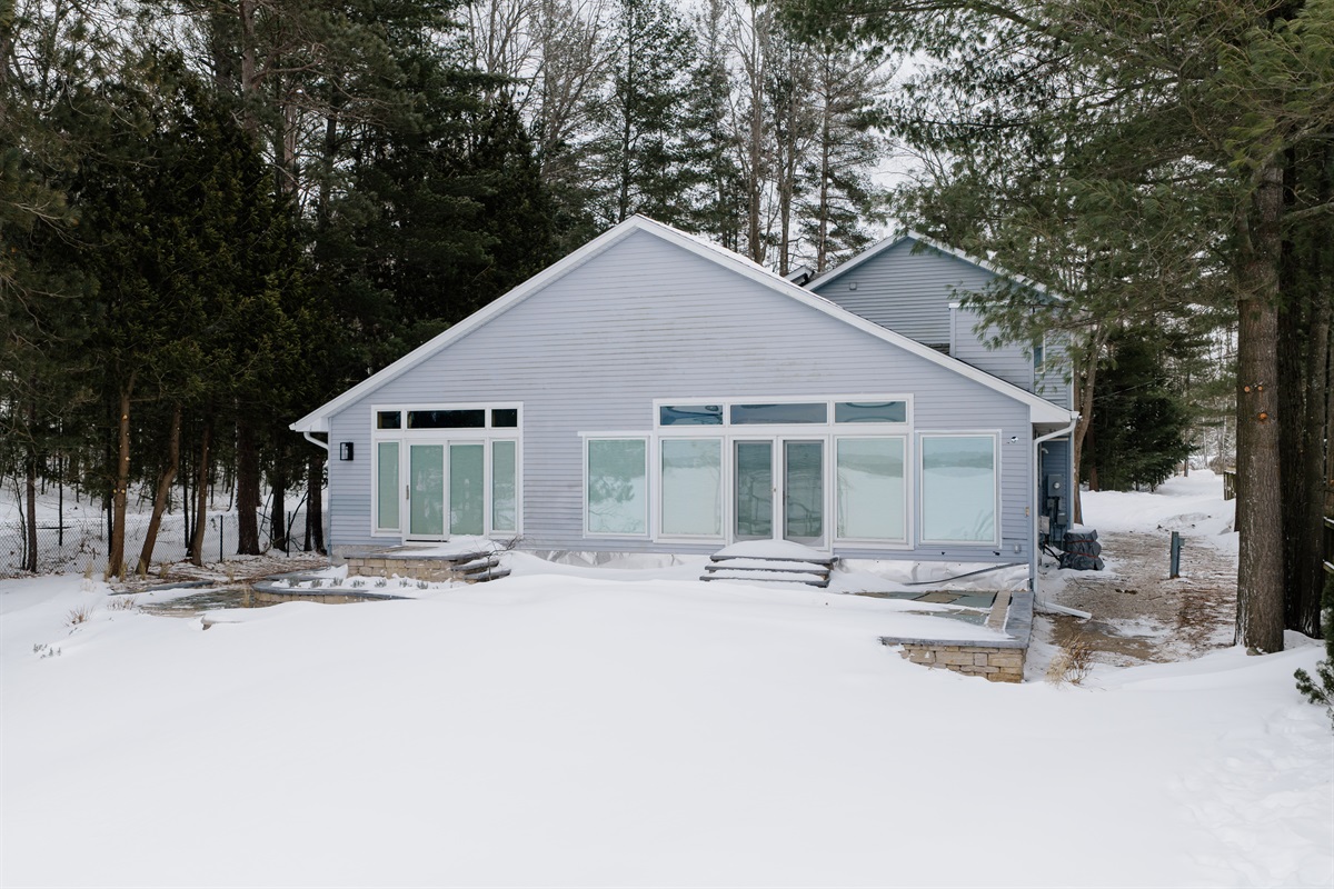 Spacious lakefront home surrounded by trees with direct waterfront access