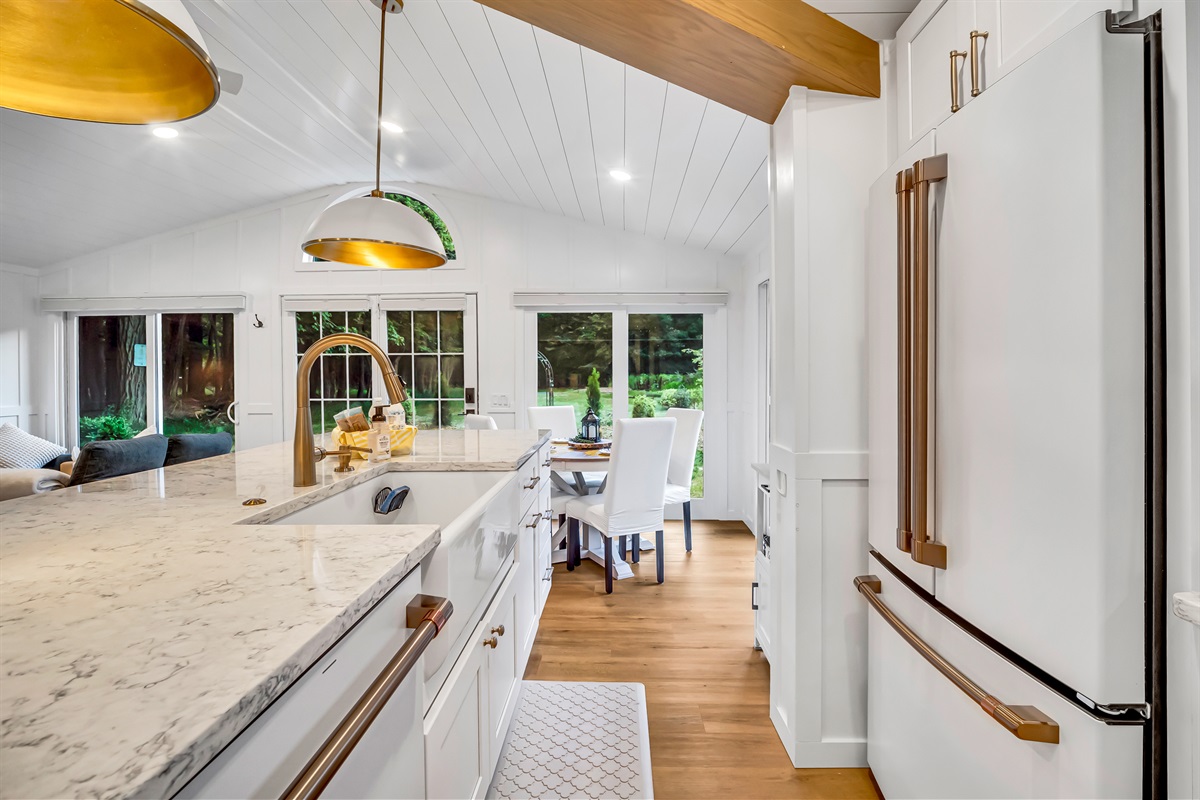 Large modern kitchen includes island counter with deep farmhouse sink