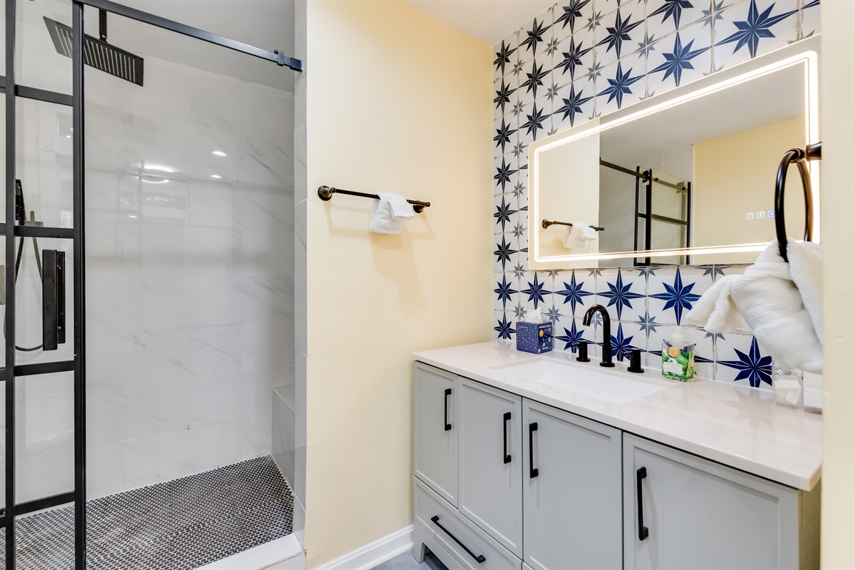 Upstairs Ensuite Full Bathroom 2: Stylish retreat featuring a sleek glass shower and charming star-patterned tiles!