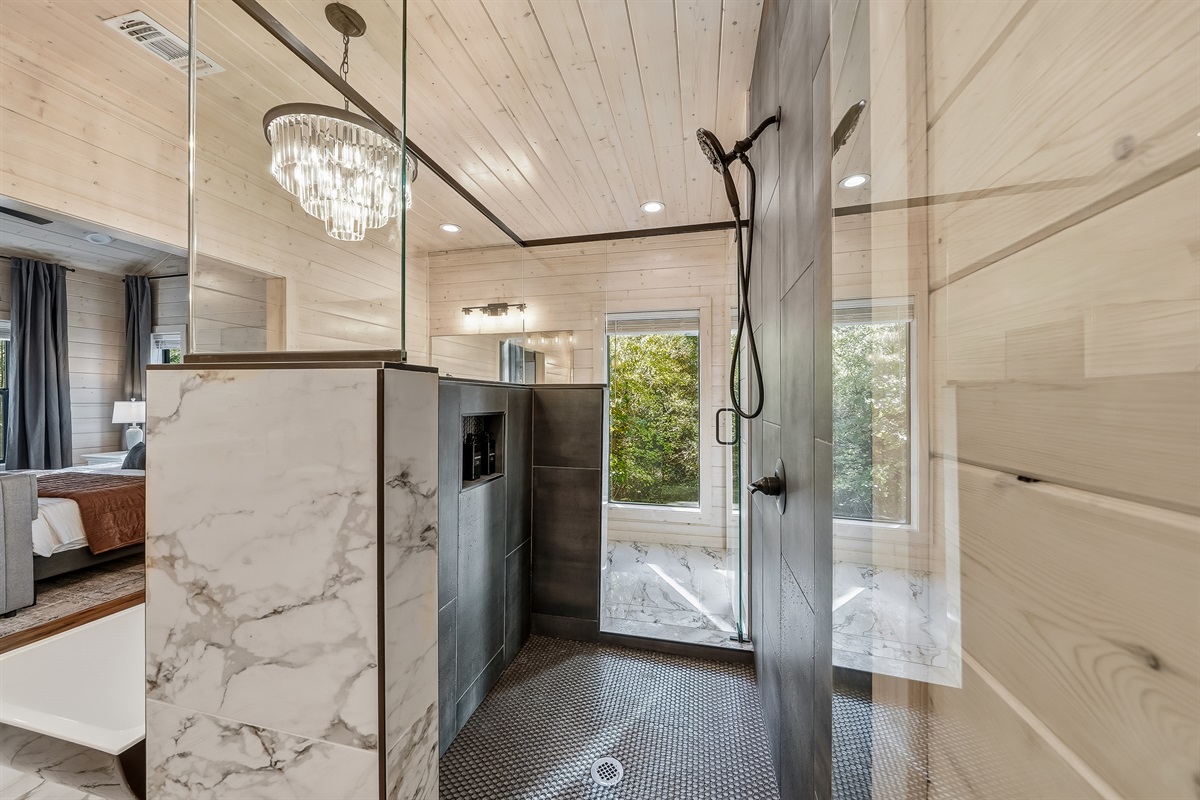 Elegant walk in shower with contrasting tile, glass surround, and curated lighting that elevates the entire space.