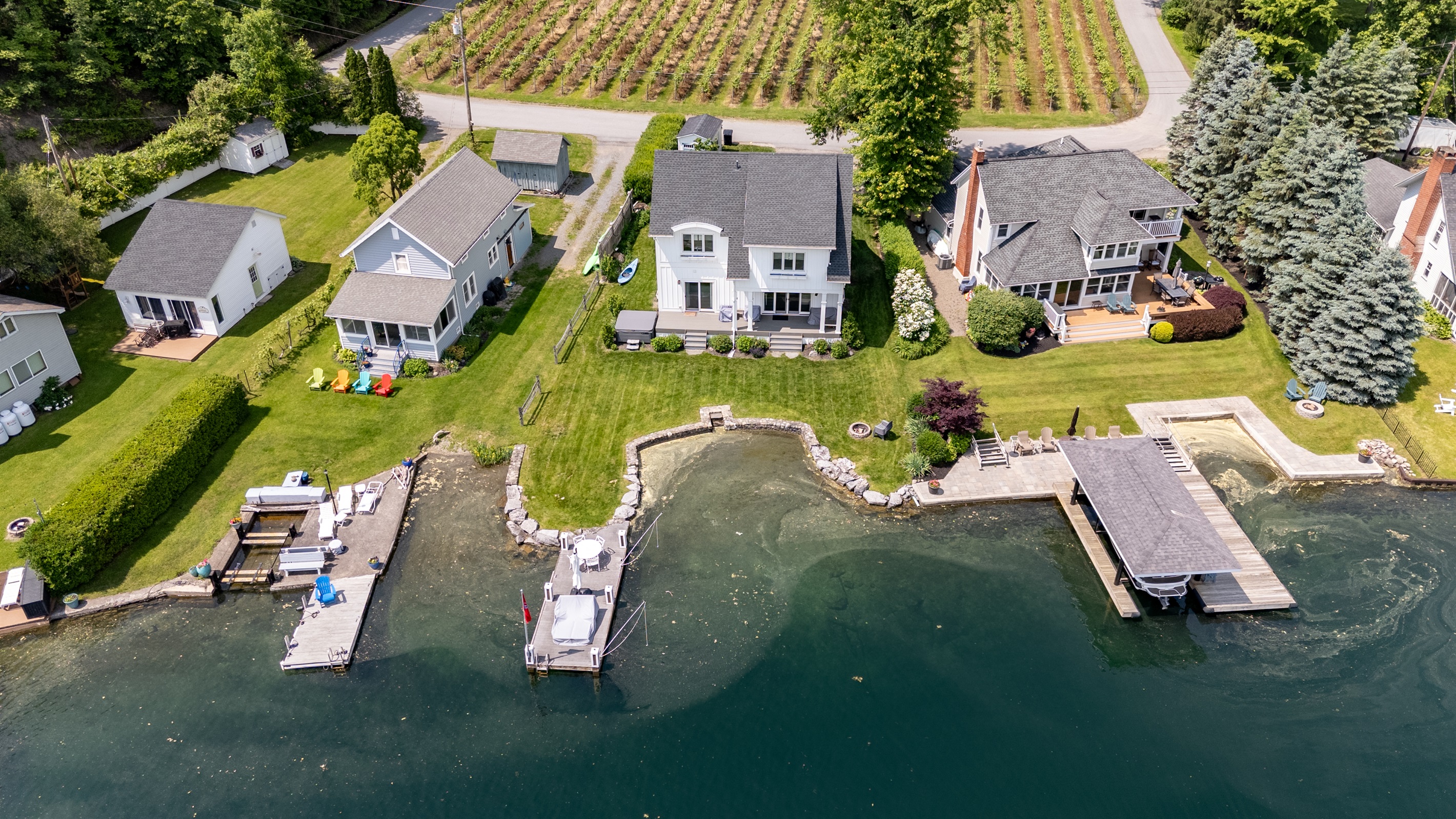 Stunning aerial view of a serene Finger Lakes waterfront retreat, complete with private dock, lush greenery, and charming lakefront homes—perfect for peaceful getaways and water adventures