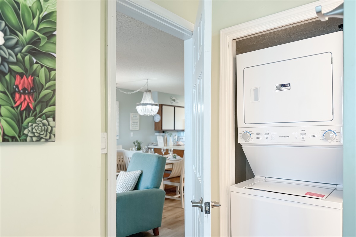 Practical utility closet with in-unit washer/dryer and ample shelving for storage.