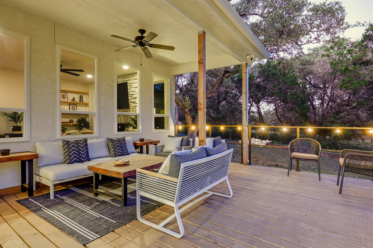 Set against a peaceful natural backdrop, this polished patio offers elegant bench seating, a ceiling fan, and ambient lighting — designed for comfort and connection.