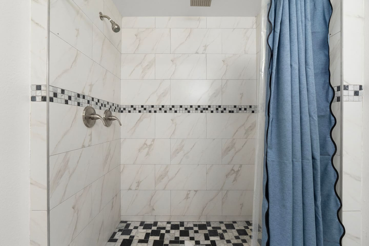 Shower with marble tile and mosaic accents —elegant and spa-inspired for a luxurious experience.