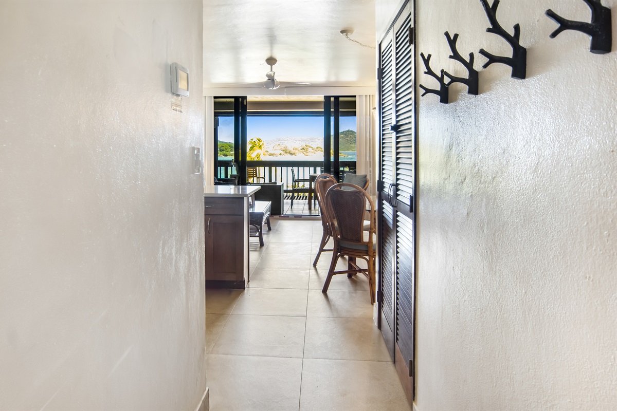 Inviting hallway that opens up to a bright living space with stunning ocean views ahead.