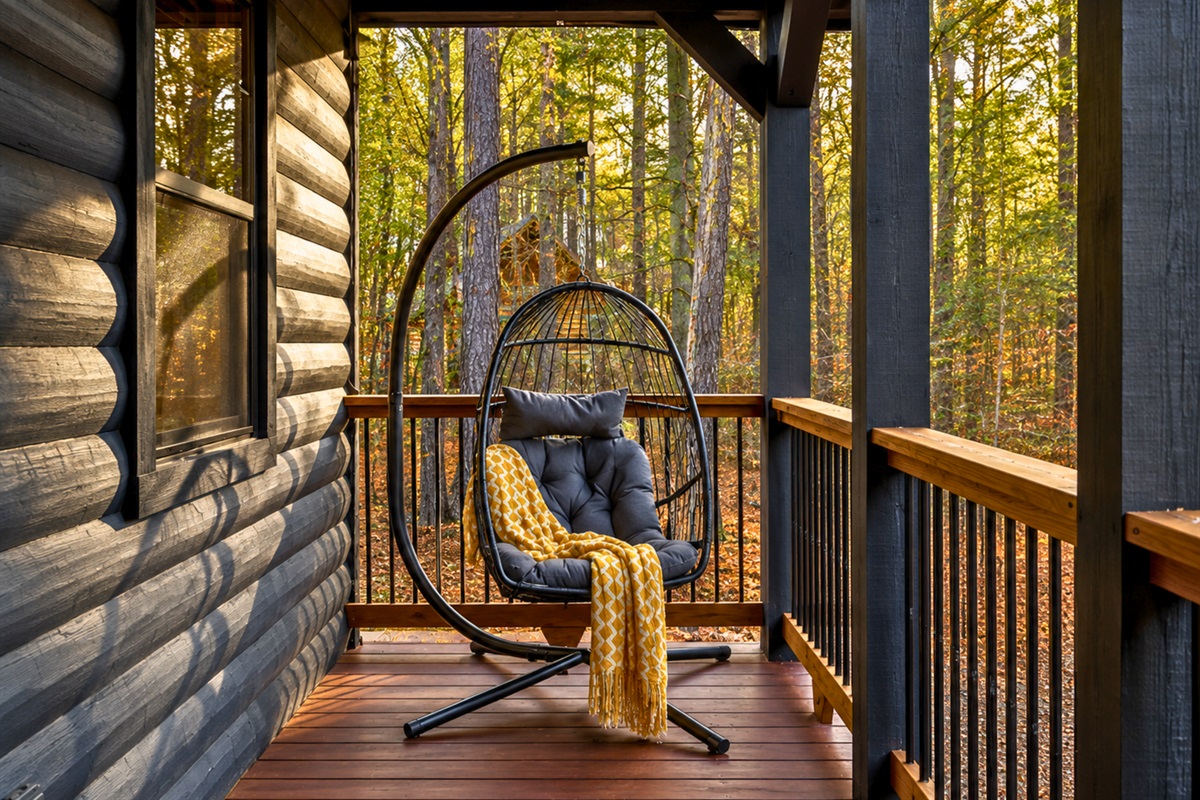 A hanging chair on the porch offers a peaceful little corner for slow mornings and quiet conversations surrounded by nature.