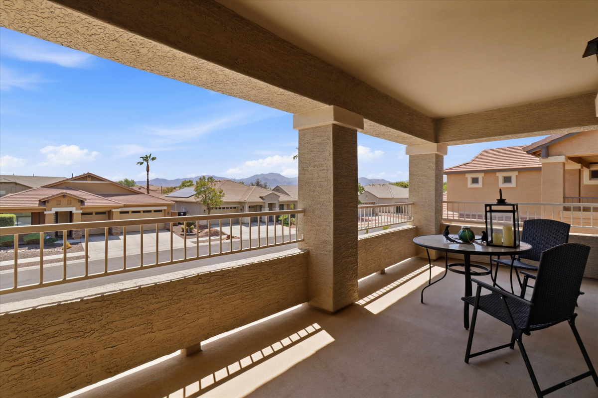 Covered balcony with table seating, neighborhood views, and a nice spot for morning coffee or fresh air.
