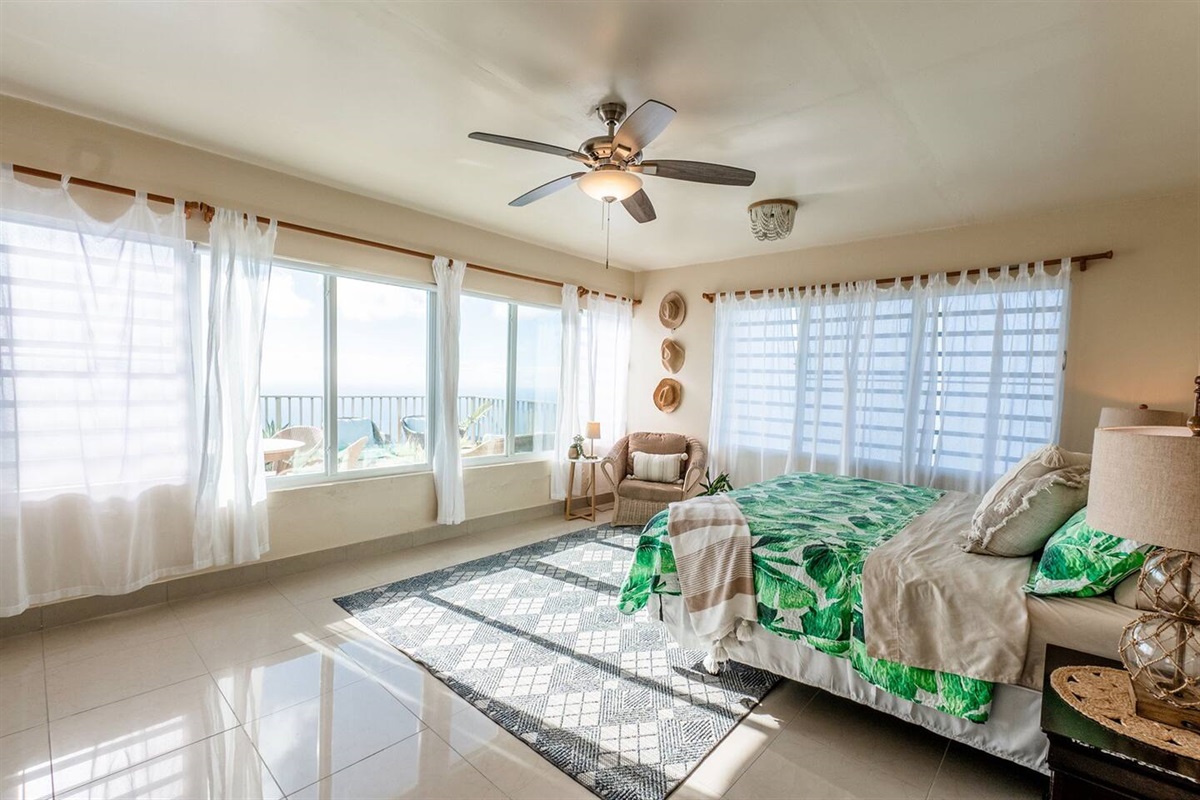 Ceiling fans in all bedrooms for cool breezes. This king primary has plenty of windows to allow the breezes to keep you cool at night. 