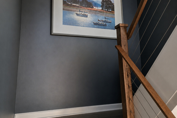 Main-level stairway with lake-inspired artwork and access between the living room and loft.