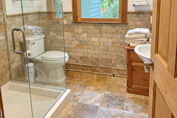 Bathroom with wide tiled shower and frame-less glass surround