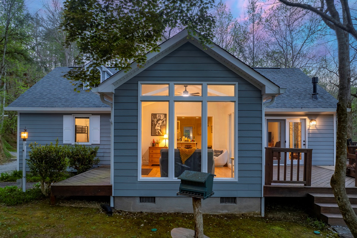 Exterior: Charming retreat surrounded by nature, with bright windows and a welcoming deck!