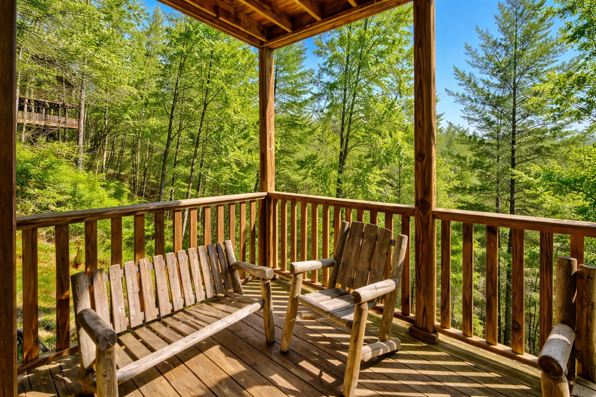 Start your morning with coffee and birdsong on this rustic wooden porch. The handcrafted chairs and peaceful forest views invite you to slow down and savor the mountain calm.