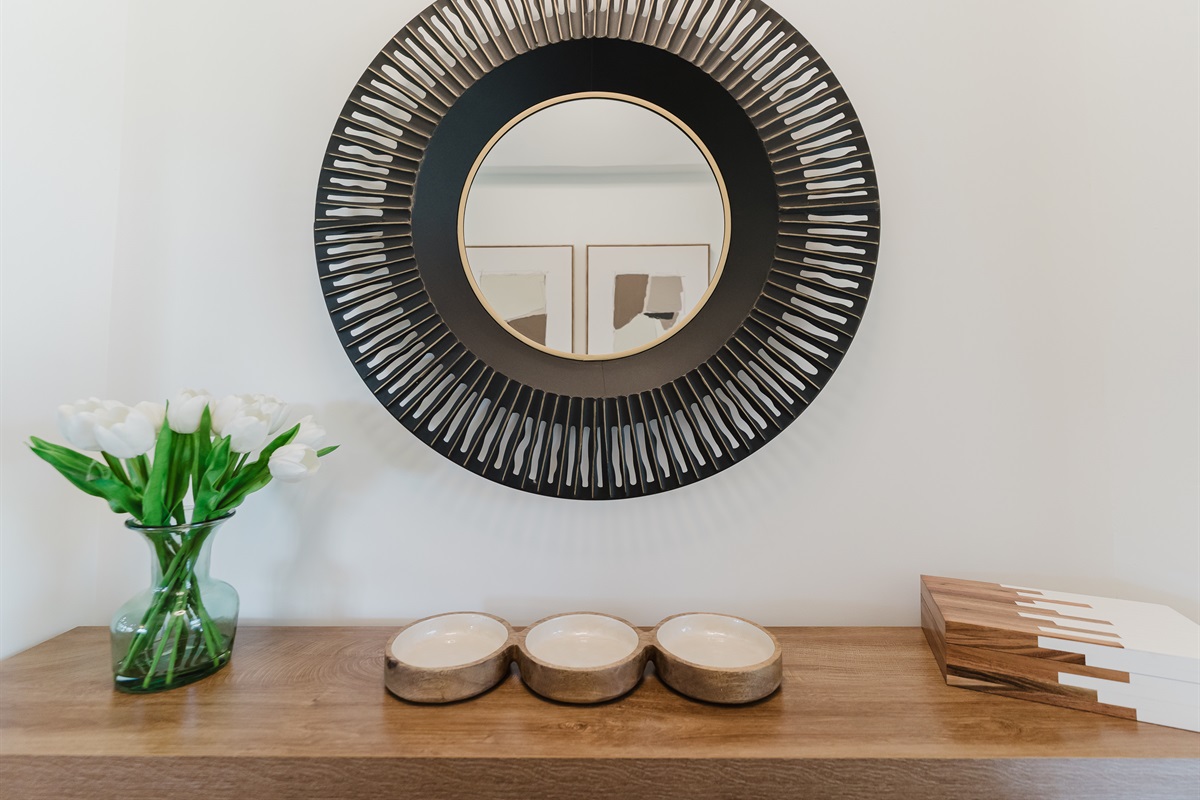 Stylish entry console with designer accents and a statement mirror, setting a warm and inviting first impression