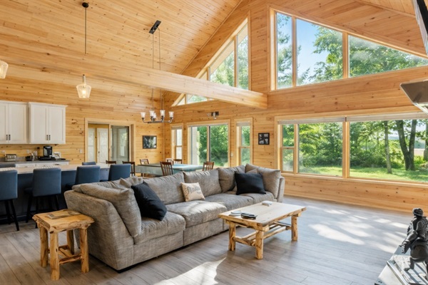 Bright open-concept living room with vaulted ceilings, lake views, and  large sectional sofa with room for everyone to relax and unwind.