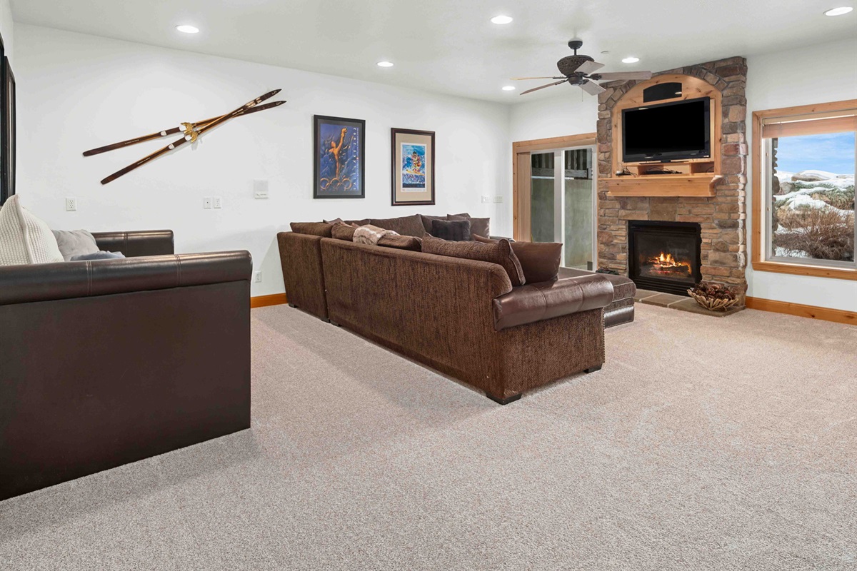 Lower-level family room with fireplace and additional sleeping options—perfect for movie nights. Pull out twin bed on the left with trundle