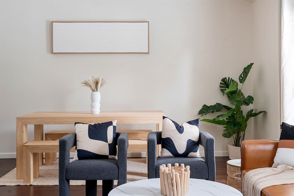Experience a serene atmosphere with a minimalist dining area complemented by contemporary decor. The space features chic chairs and a tasteful plant