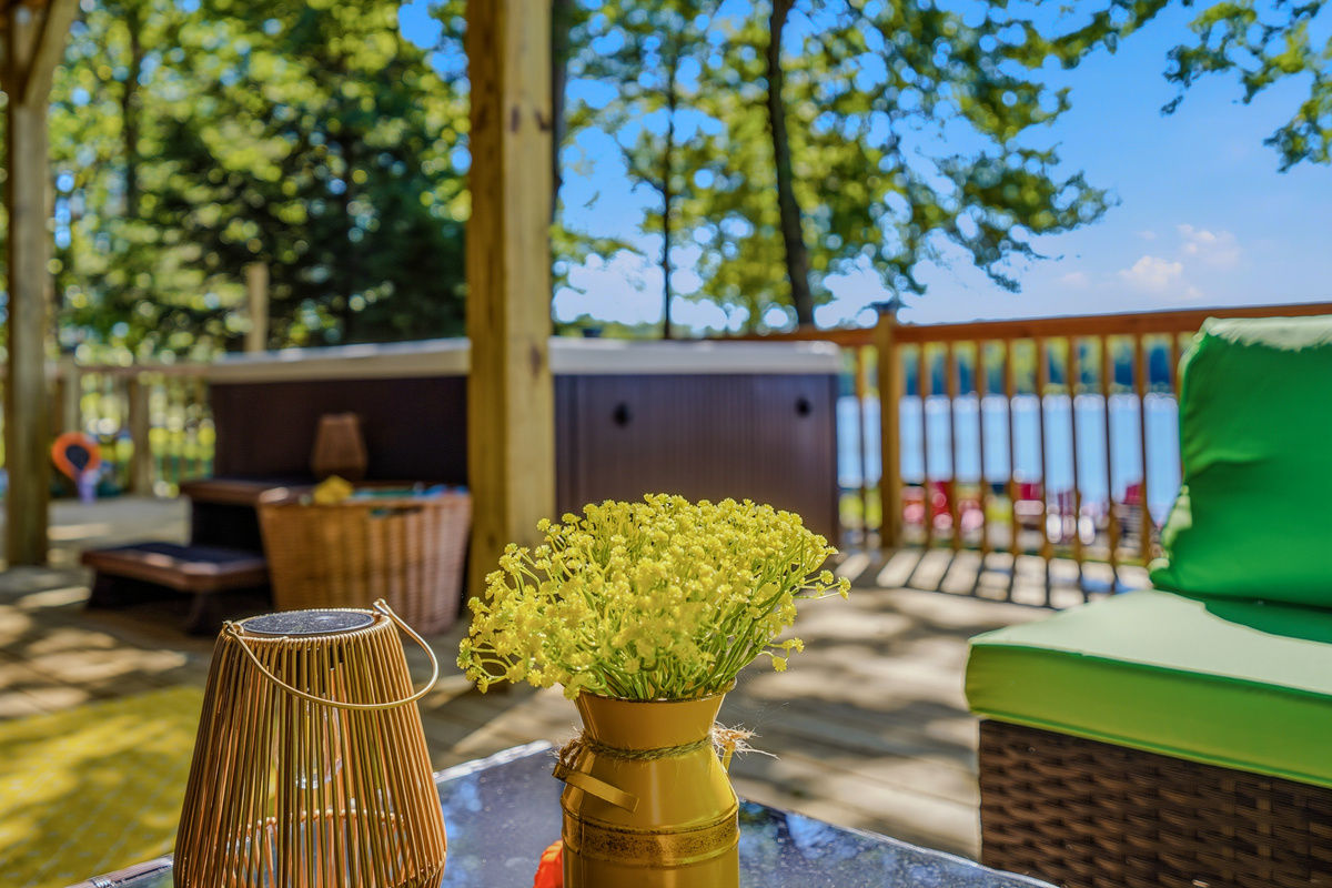Lower deck detail — hot tub, outdoor seating, and the lake as your backdrop