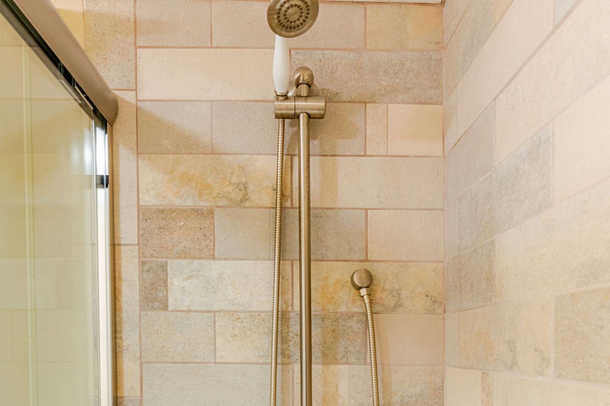 A luxurious master bathroom featuring a beautiful shower with elegant glass doors and a stylish showerhead.