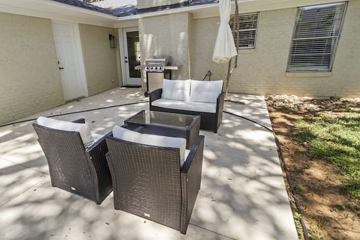 Outdoor patio area with seating and grill setup for casual evenings and outdoor dining.