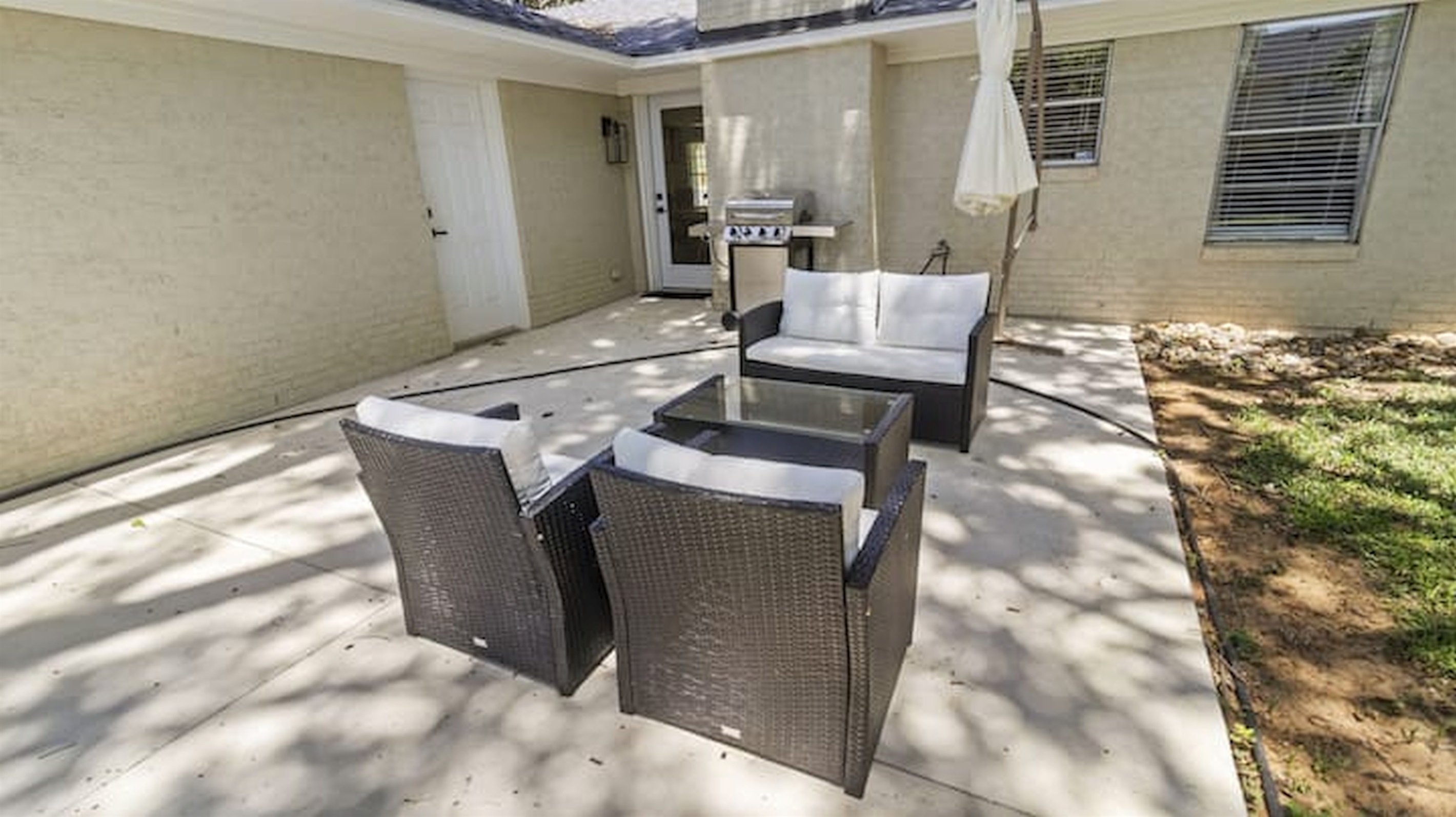 Outdoor patio area with seating and grill setup for casual evenings and outdoor dining.